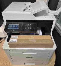 A Brother MFC-L8690CDW color laser printer operating in a West Yorkshire office.